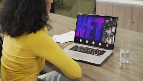 video de una mujer afroamericana haciendo una videollamada nft en una computadora portátil con varios compañeros de trabajo