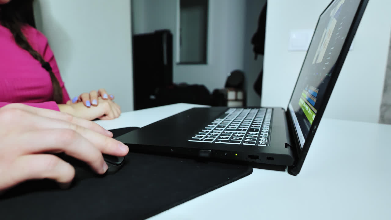 Slow motion shot of man shows woman through laptop video edit pointing at screen