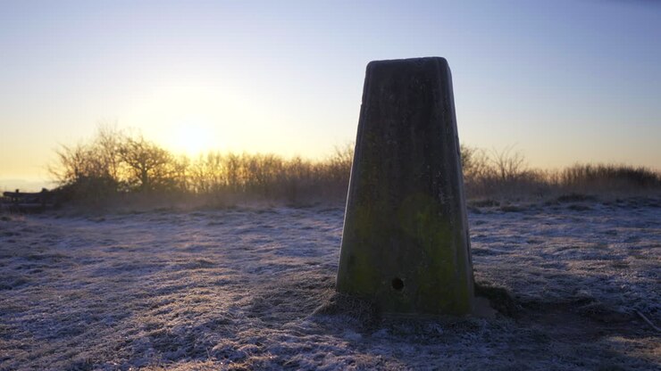 Primo piano di forte gelo invernale su pietra miliare con sole basso 4K.