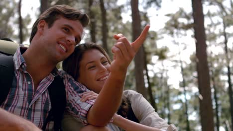 smiling couple pointing away on a hike