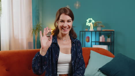 mujer feliz agente inmobiliario levantando la mano mostrando las llaves de una nueva casa comprando o alquilando una propiedad