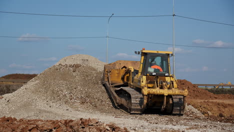 yellow bulldozer and a pile of gravel at a construction site