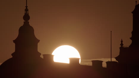 yellow orb of sun rises over old parliament house on riddarholmen stockholm