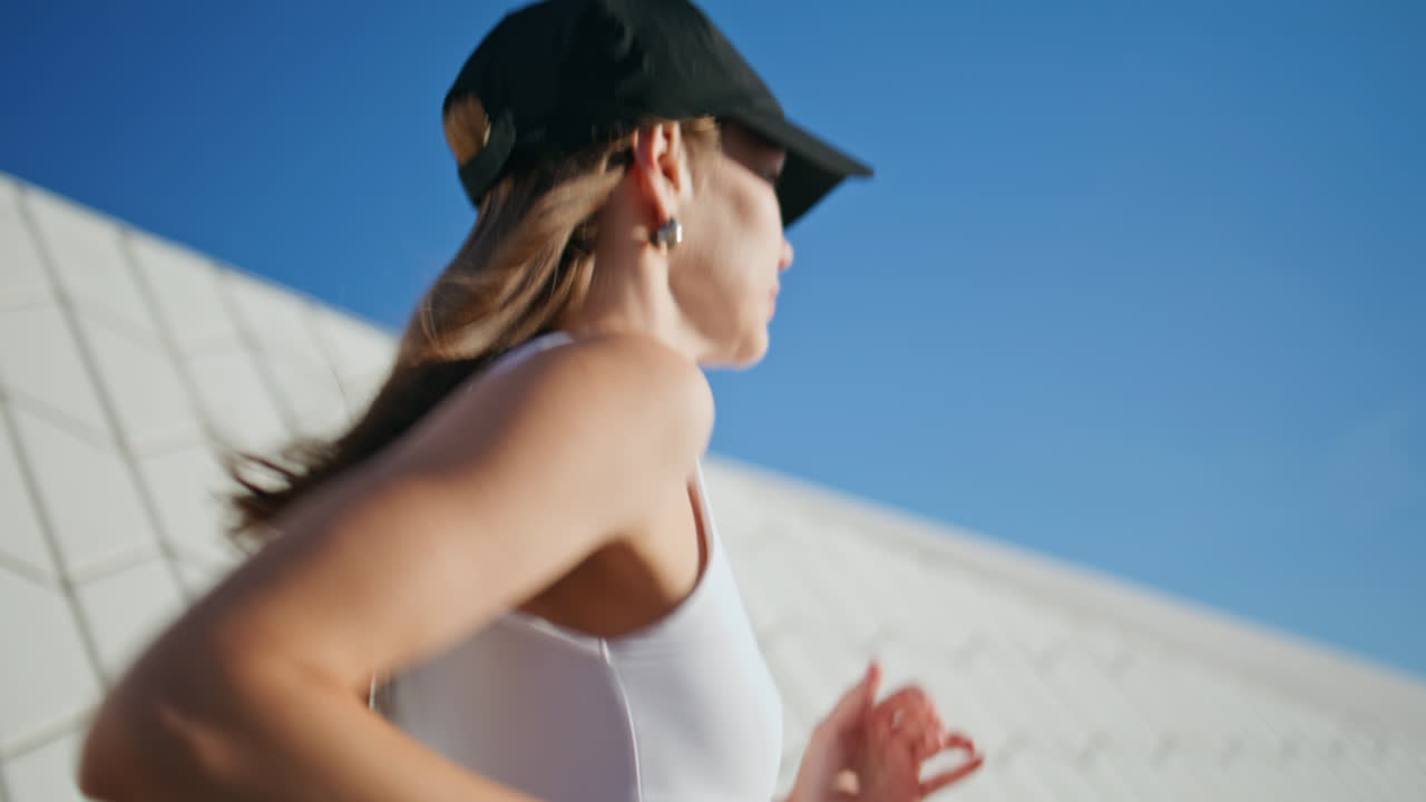 Woman enjoying workout sunny modern street closeup. Young sportswoman running