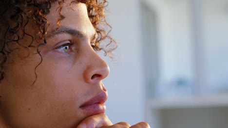 Side-view-of-Caucasian-male-graphic-designer-with-hand-on-chin-working-at-desk-in-office-4k