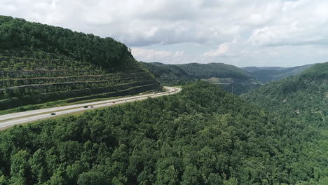 aerial view of highway through mountainous forest