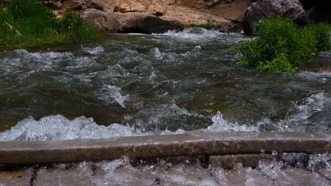 Fließendes-Flusswasser-Fließt-Schnell-über-Eine-Brücke