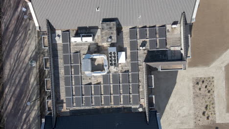 antena de arriba hacia abajo de paneles solares en la parte superior de una gran casa de ancianos - drone levantando