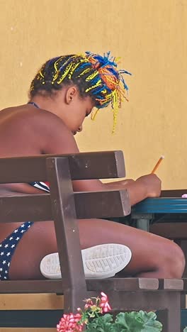 african ethnicity girl painting on the table