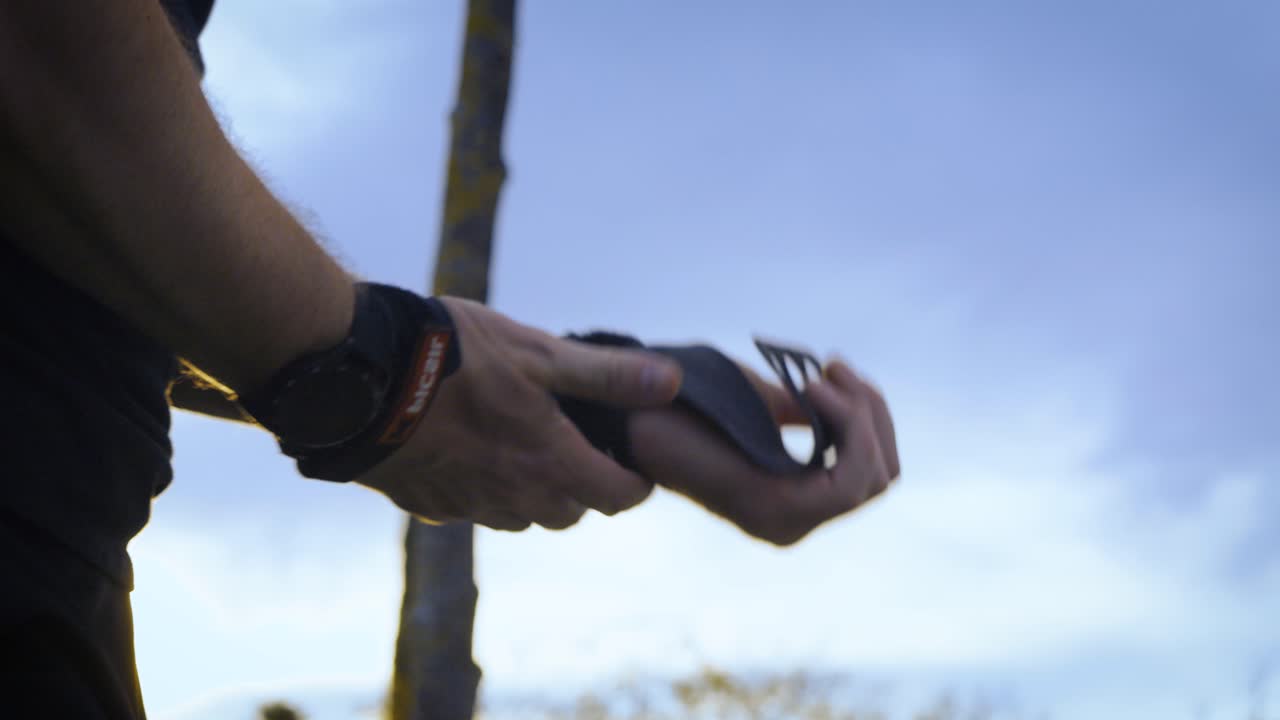 운동하기 전에 체조 핸드 그립을 착용하는 남자의 클로즈업 샷