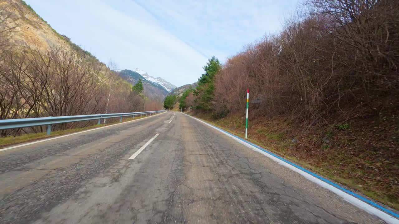 Road trip going up the mountain in the Pyrenees in Catalonia camera located in front of the car snow in back mountain