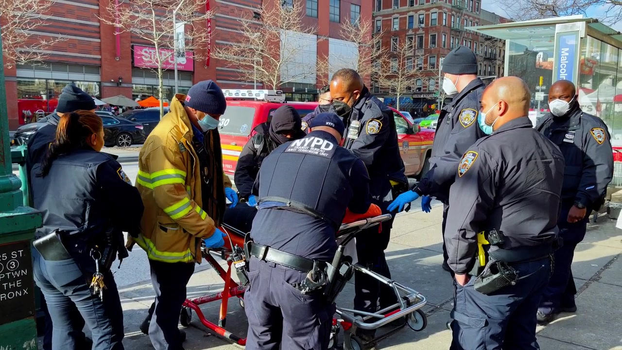 New York, USA, 9 March 2022: Emergency responders with stretcher outside Harlem subway. NYPD, EMS, and firefighters handle a stretcher near 125th Street subway entrance.
