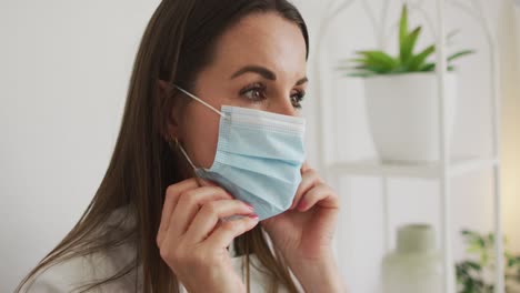 Portrait-of-caucasian-female-beautician-putting-face-mask-on