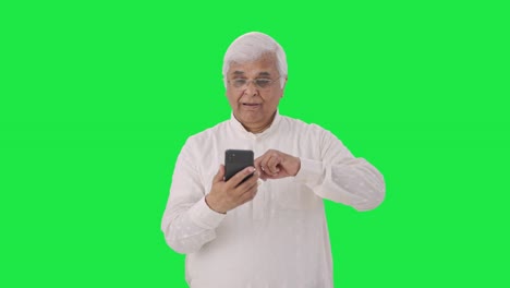 Sleepy-Indian-old-man-scrolling-through-phone-Green-screen