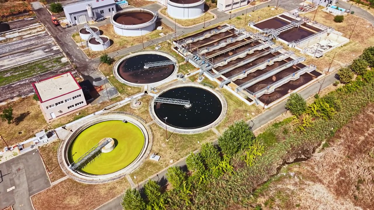 Water treatment facility overview with processing units and greenery in the area