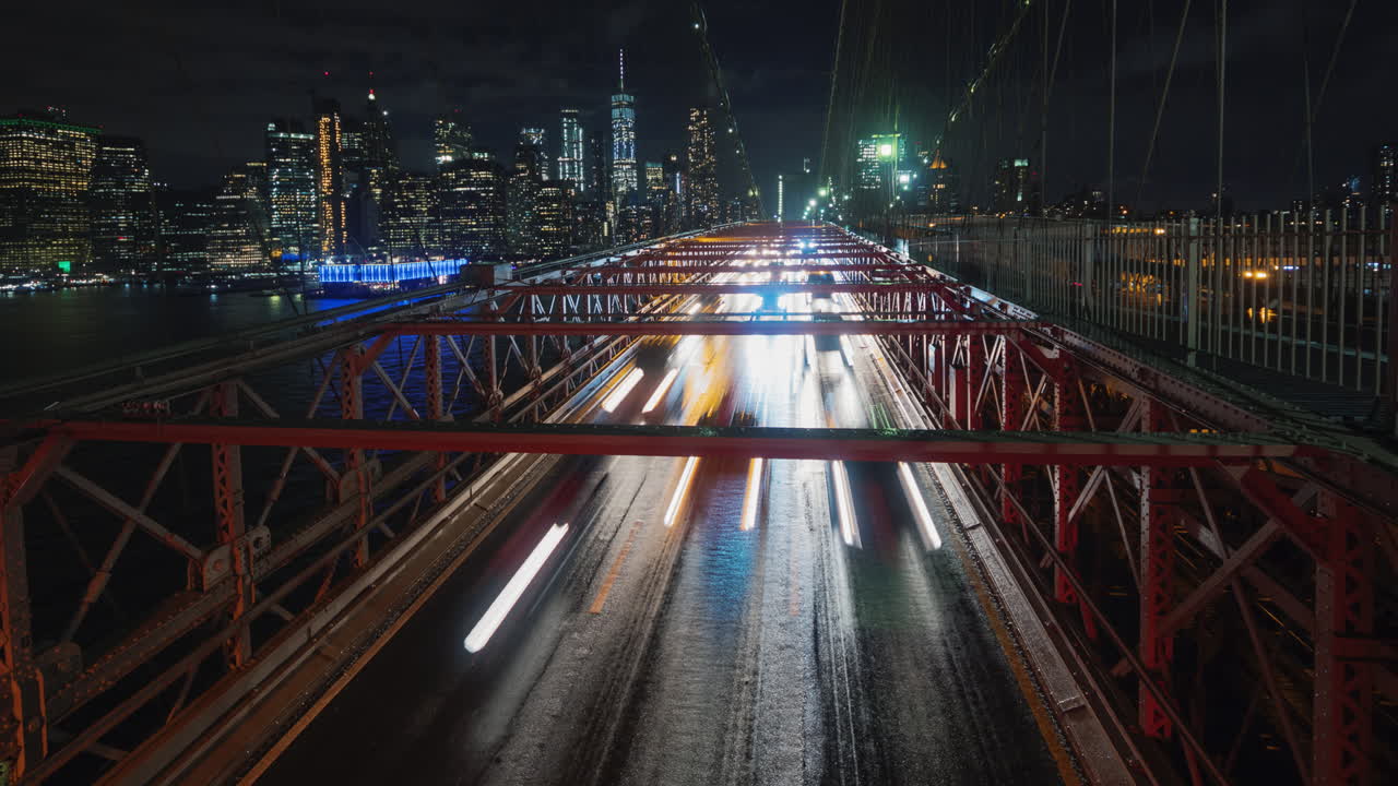 뉴욕 밤의 실루엣을 배경으로 브루클린 다리 위의 교통 차량