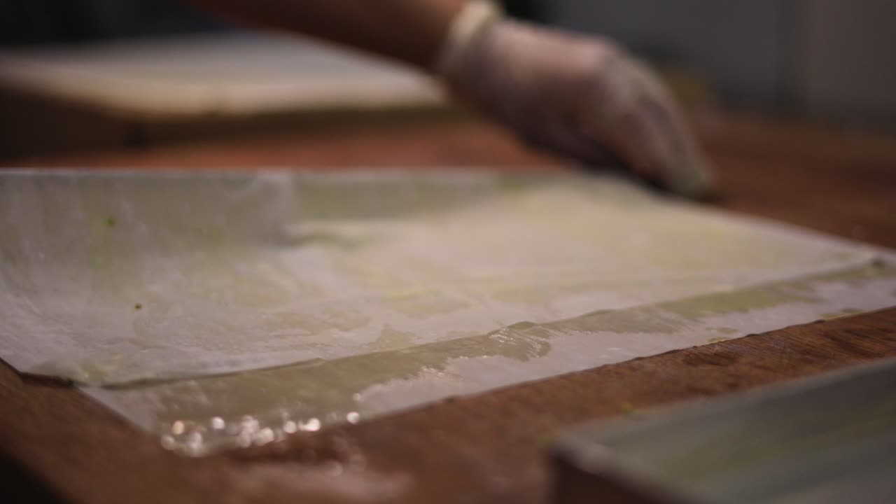 finas capas de masa se preparan en la mesa de pastelería para postres con jarabe