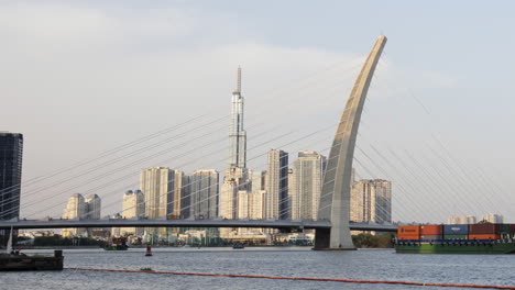 a dynamic timelapse of saigon river highlighting a prominent bridge and moving cargo vessels as the camera smoothly zooms out