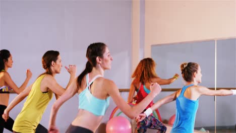 woman smiling while performing aerobics exercise with the team