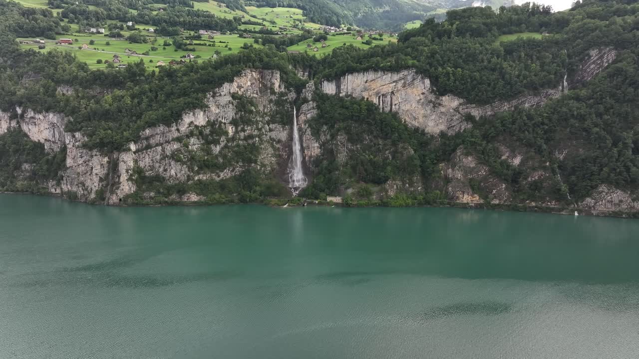 Waterfall cascades into Walensee, serene Swiss landscape, nature's beauty