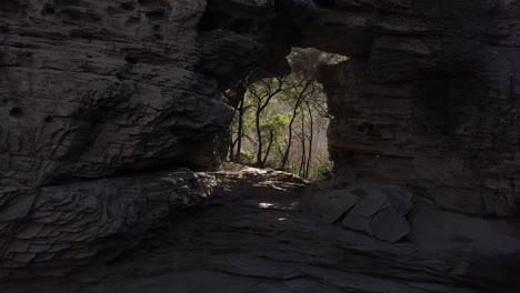 naturalny łuk utworzony w ogromnej skale z przebłyskiem lasu pełnego światła