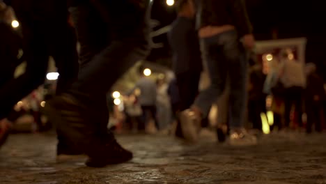 promenade paved on stone tails full of people walking around night bars in korca, albania