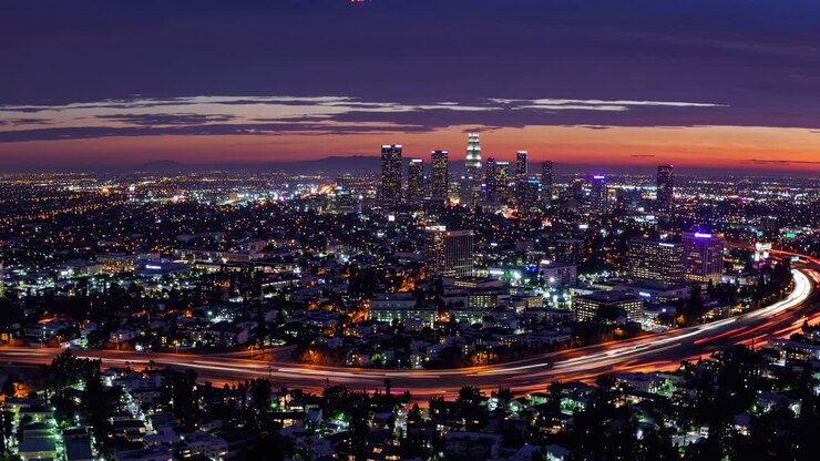 Aerial view of a cityscape at dusk, showcasing vibrant lights and a dynamic skyline