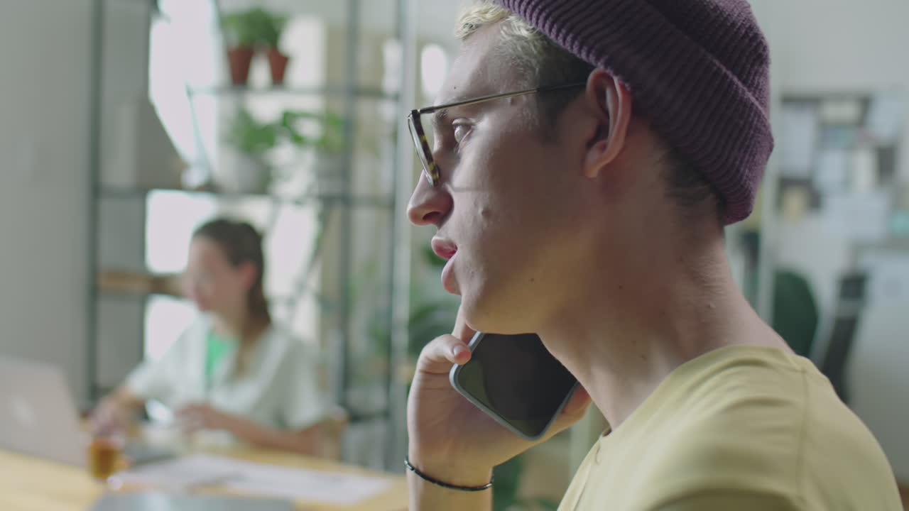 Gen Z Man Talking on Mobile Phone in Office