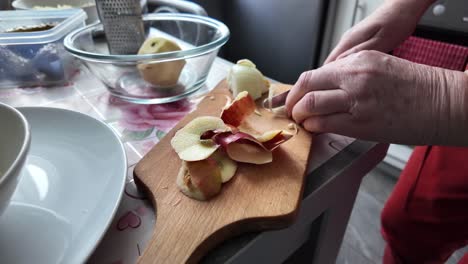 an elderly women cuts an onion for a traditional salad