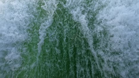 close-up of the wake of water behind a fast-moving motor boat in a clear sky day, blue sea, water surface