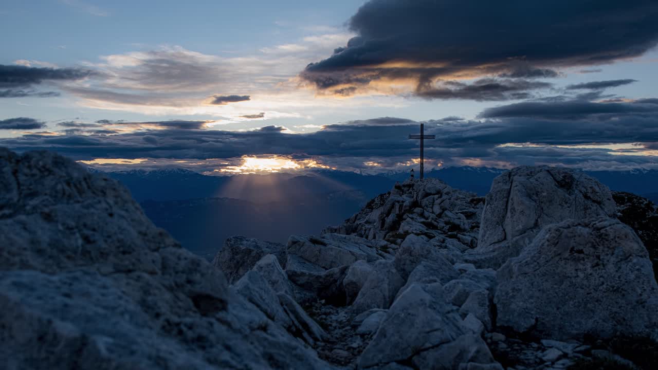 gente al lado de la cruz en la cima del monte corno bianco al atardecer, italia