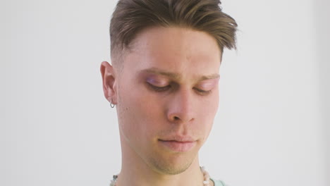 serious man looking at camera and moving pink flower