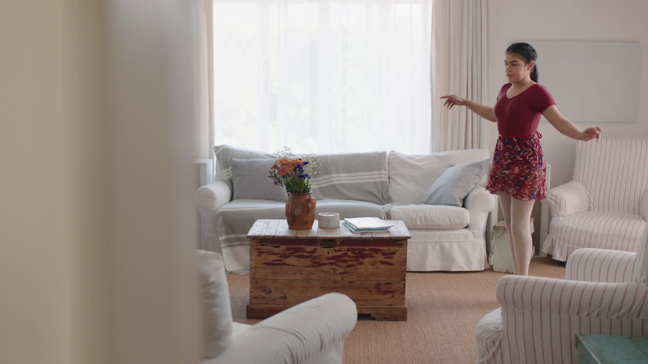 행복한 십대 소녀가 춤을 추고 집에서 발레 춤 동작을 연습하고 리허설을 즐기고 주말에 재미를 느끼고 있습니다.
