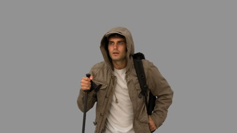 Man-with-a-coat-trekking-on-grey-screen