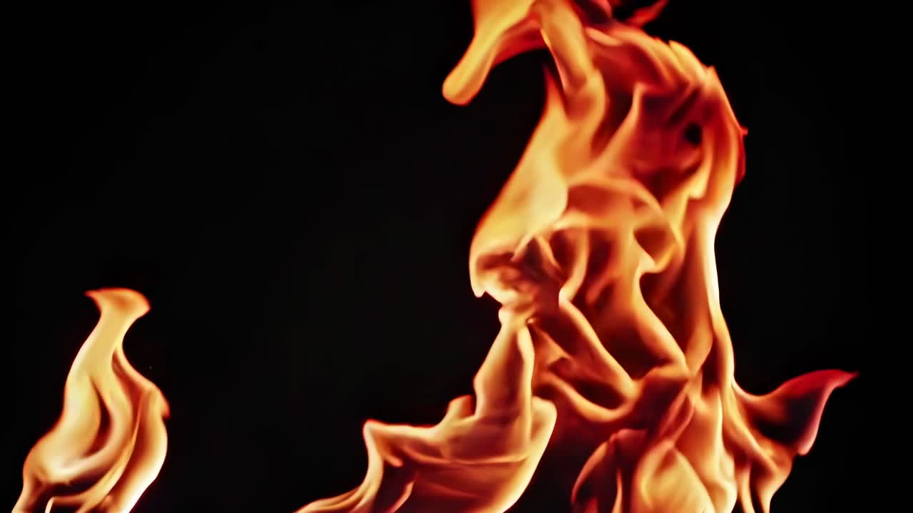 Close-up video of vibrant flames against a dark background, captured from a low angle