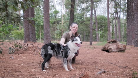 Eine-Junge-Frau-Und-Ihr-Australischer-Schäferhund-Genießen-Einen-Verspielten-Moment-Im-Park,-Der-Hund-Reagiert-Mit-Freude