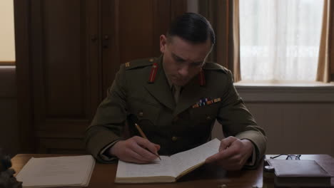 military officer writing at a desk