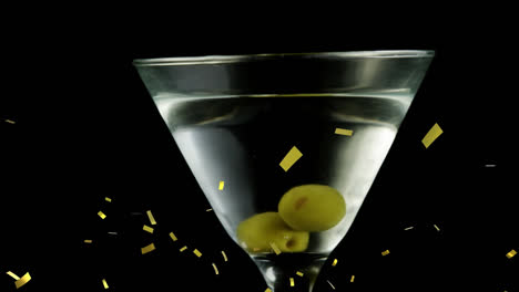 animation of confetti falling over wine and olives in wine glass on black background