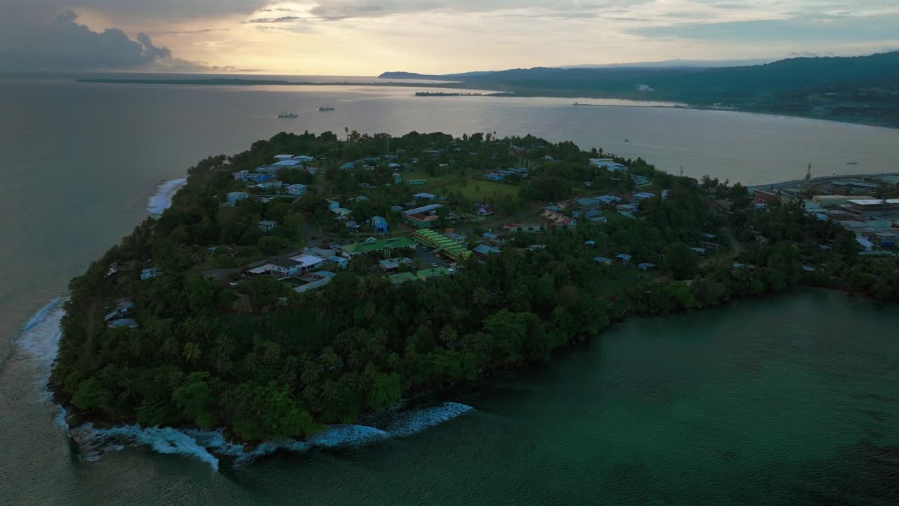 Wewak Papua New Guinea aerial drone PNG morning sunrise clouds summer dry season Boram Road cape Wewak Hill costal town Seawall Port Dogreto Bay meni beach cargo vessel boat waves circle left