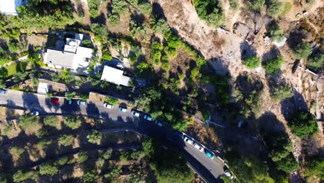 Lindos-village-in-Rhodes,-Greece-with-Acropolis-of-Lindos,-houses-and-Mediterranean-sea-during-the-day-filmed-with-the-drone