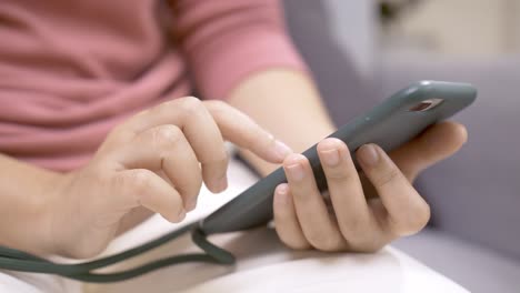 Close-up-focus-on-woman-hands-using-a-smartphone-to-social-media