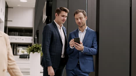 two handsome businessmen having talk in office