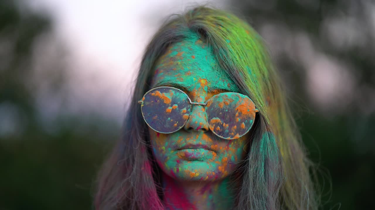 retrato de una mujer de pie cubierta de polvo de colores en el festival de holi.