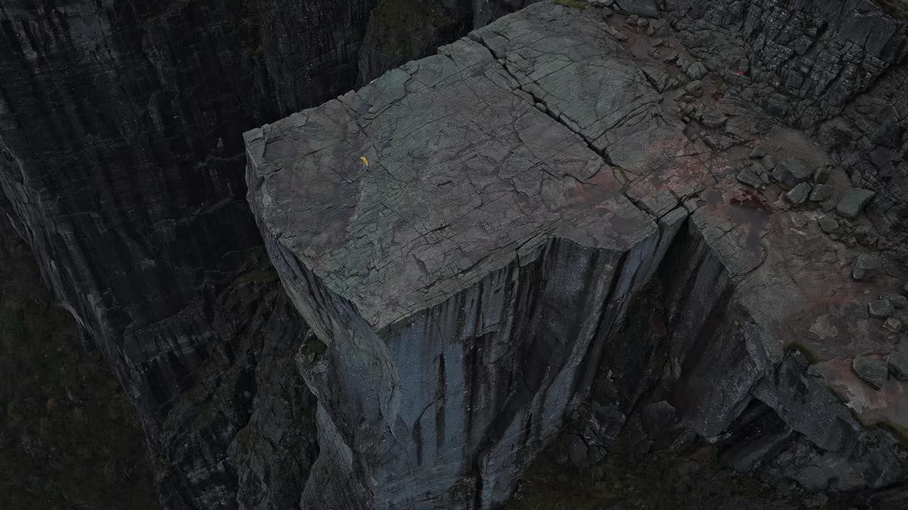 Gün batımında Preikestolen falezinin drone çekimi, kenarda yalnız bir figürle.
