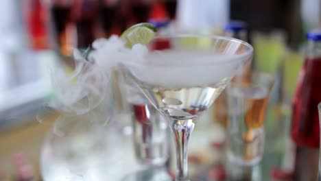 smoking martini cocktail in a conical glass with wafting vapor smoking martini cocktail in a conical glass with wafting vapor