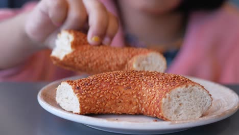 child hand pick a fresh bagel bread