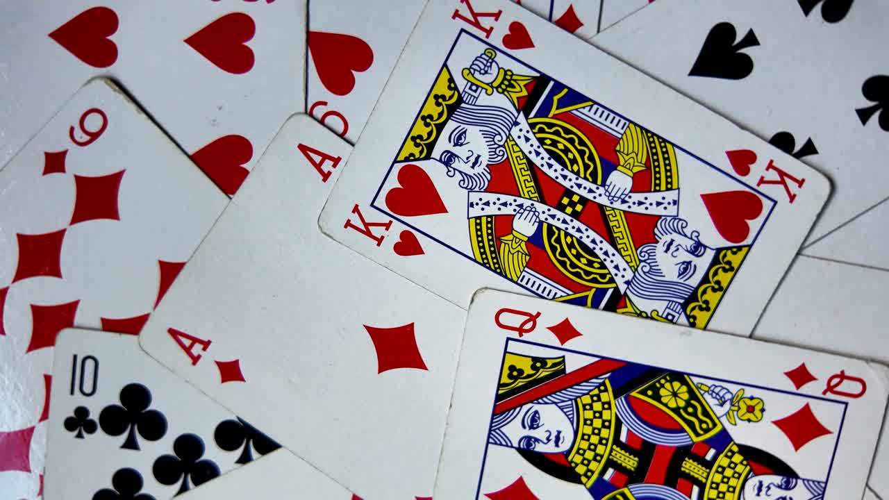A deck of playing cards spinning, vibrant red and black suits with Ace King and Queen on top, spinning backdrop background