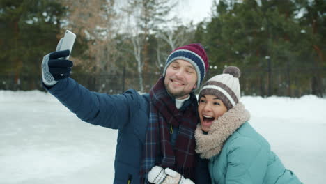couple taking a selfie on an ice rink in winter