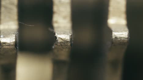 Clockwork turn motion of brass cog wheel teeth clicking forward MACRO shot
