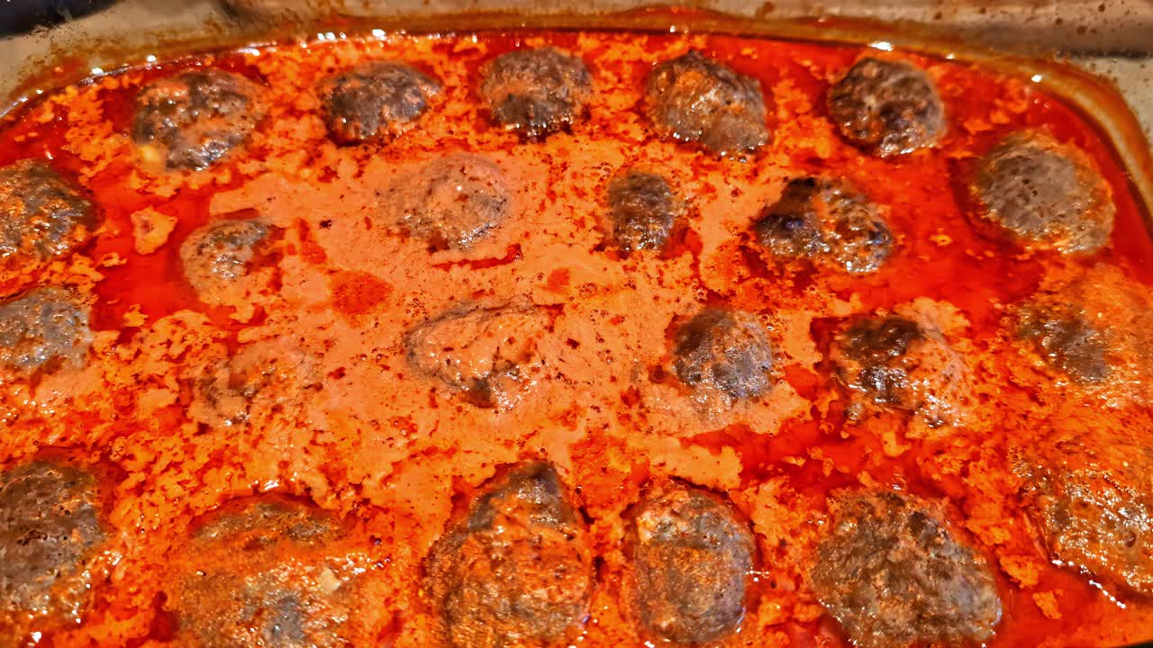 Dish of meatballs simmering in a red tomato based sauce Italian cuisine food